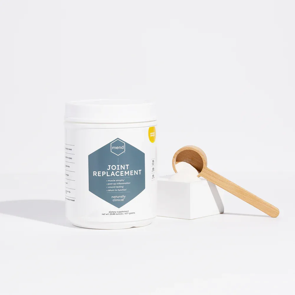 Jar of MEND Joint Replacement supplement powder with a wooden scoop.