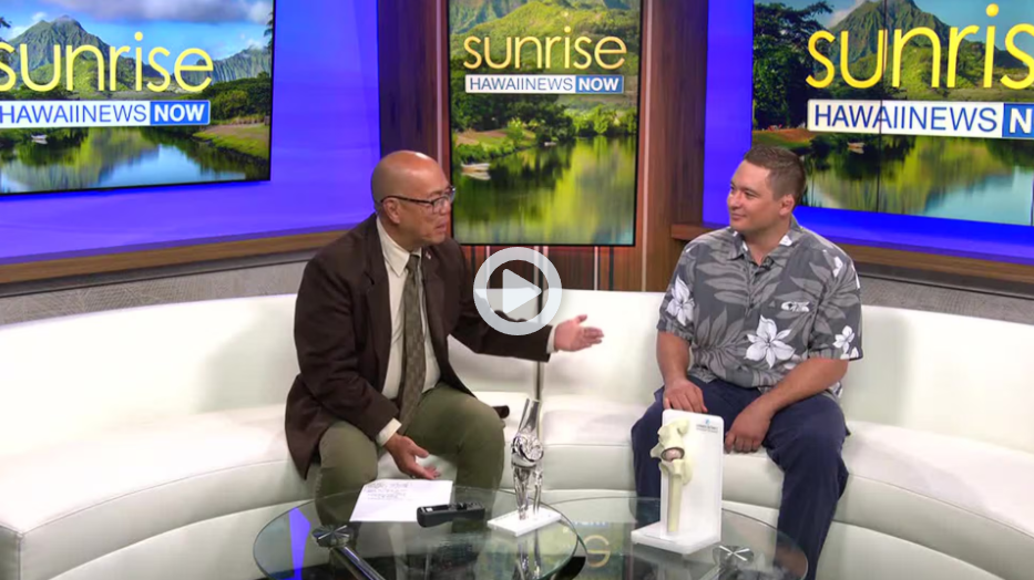 Dr. Paul Morton discusses joint replacement on the Hawaii News Now Sunrise set, with knee and hip implant models on the coffee table.
