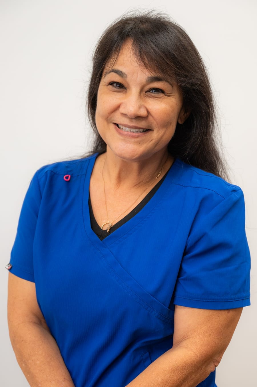 Carol, a Pacific Bone & Joint team member, smiling in royal blue scrubs.