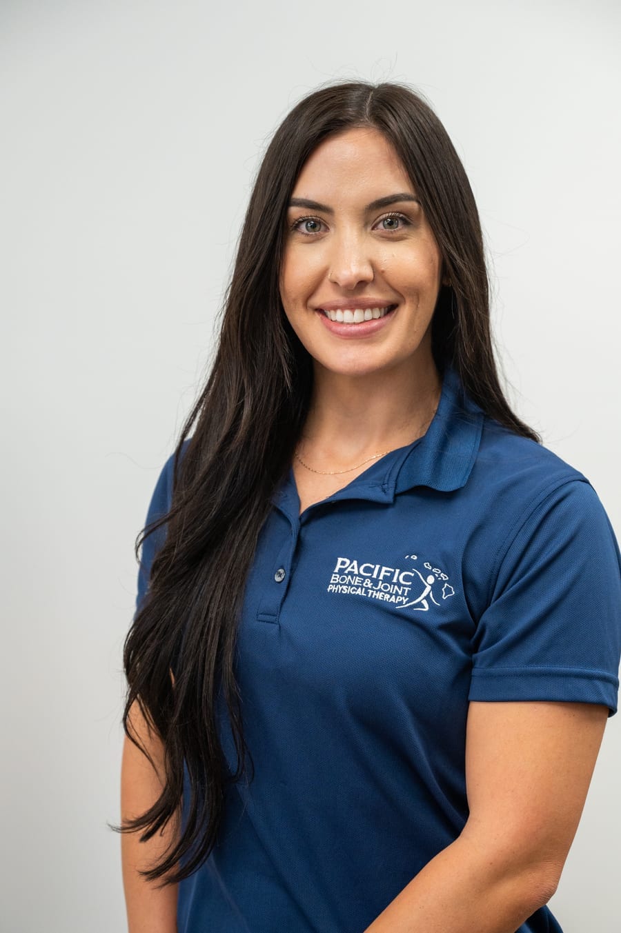 Chelsea Miller of the Pacific Bone & Joint Physical Therapy team in Honolulu, wearing a navy PB&J polo.