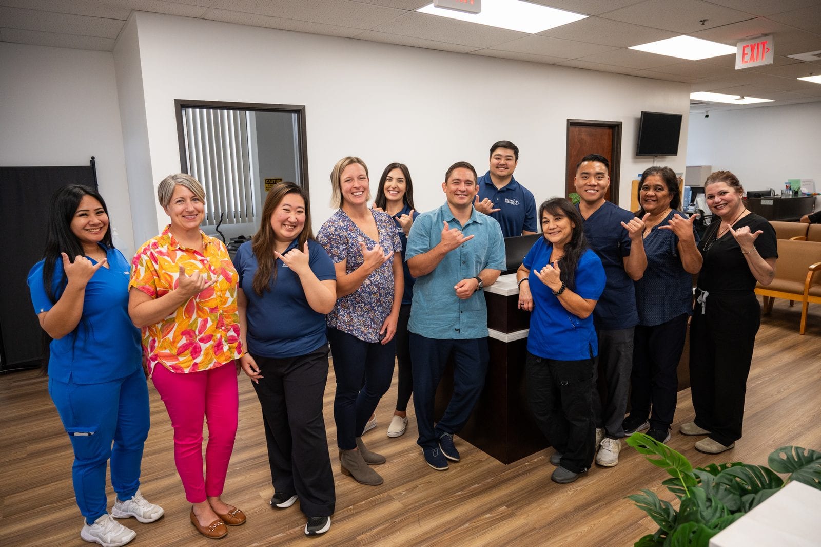 The Pacific Bone & Joint team throws shakas at the front desk of their Honolulu clinic.