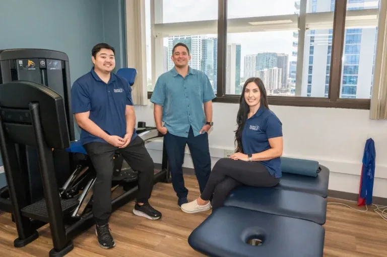 Dr. Paul Morton with PB&J Physical Therapy team members in the Honolulu clinic gym overlooking the city.